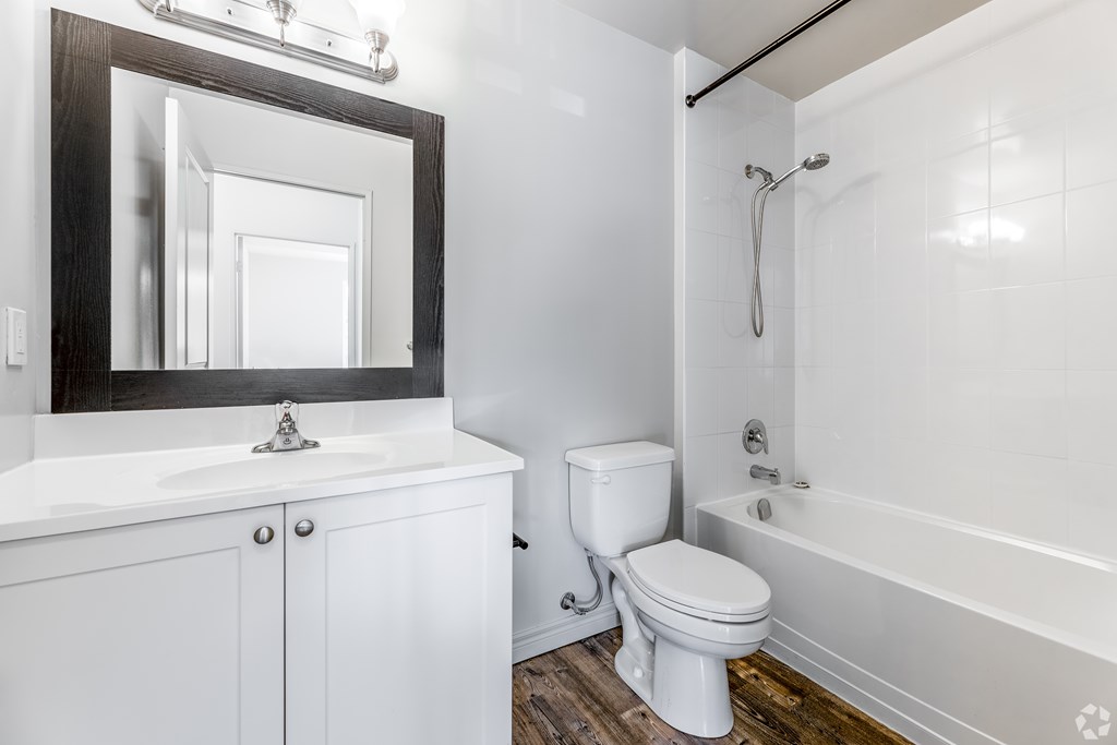 A white bathroom with a toilet, sink, and bathtub.