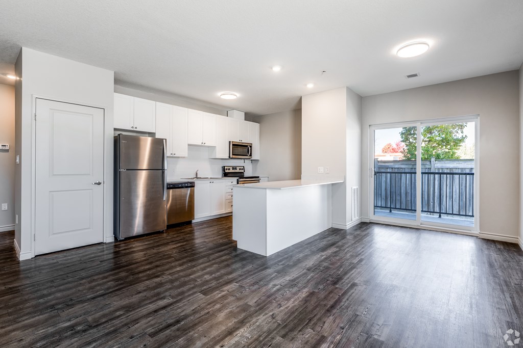 A kitchen with white cabinets and a stainless steel refrigerator.