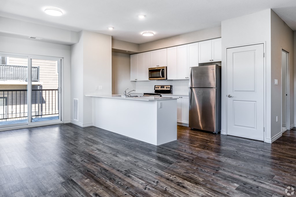 A kitchen with a white counter and a stainless steel refrigerator.