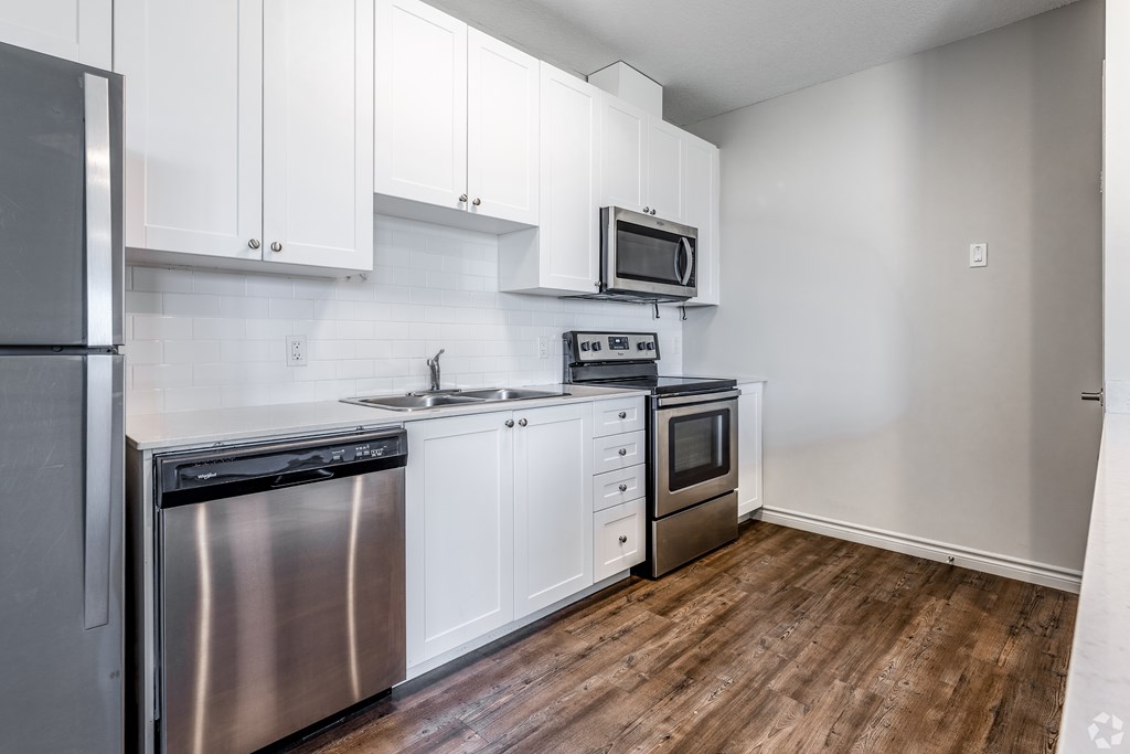 A kitchen with white cabinets and stainless steel appliances.