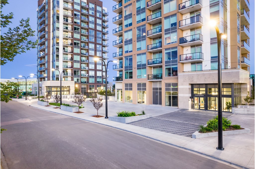 A modern apartment building with a well-maintained courtyard in front.