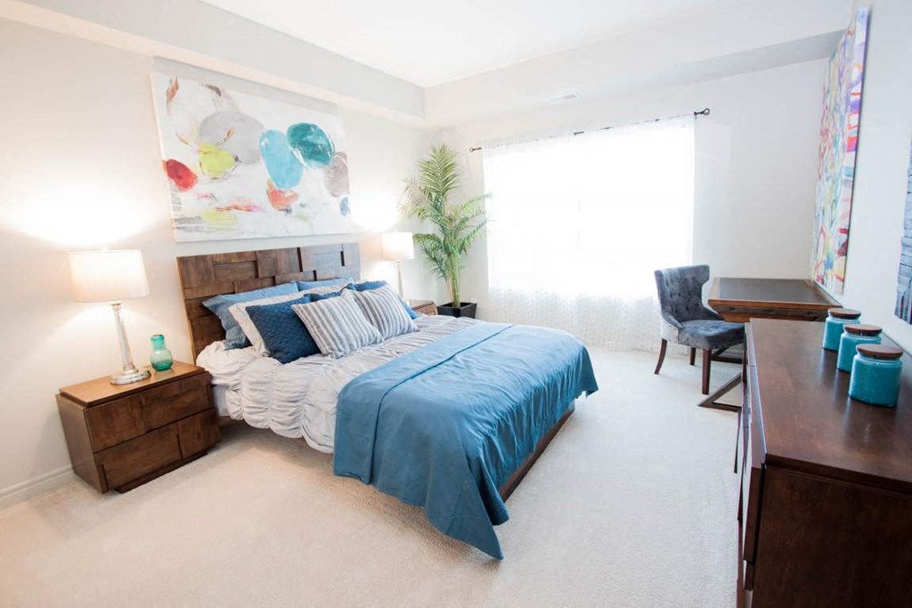 a bedroom with a bed and a desk and a window