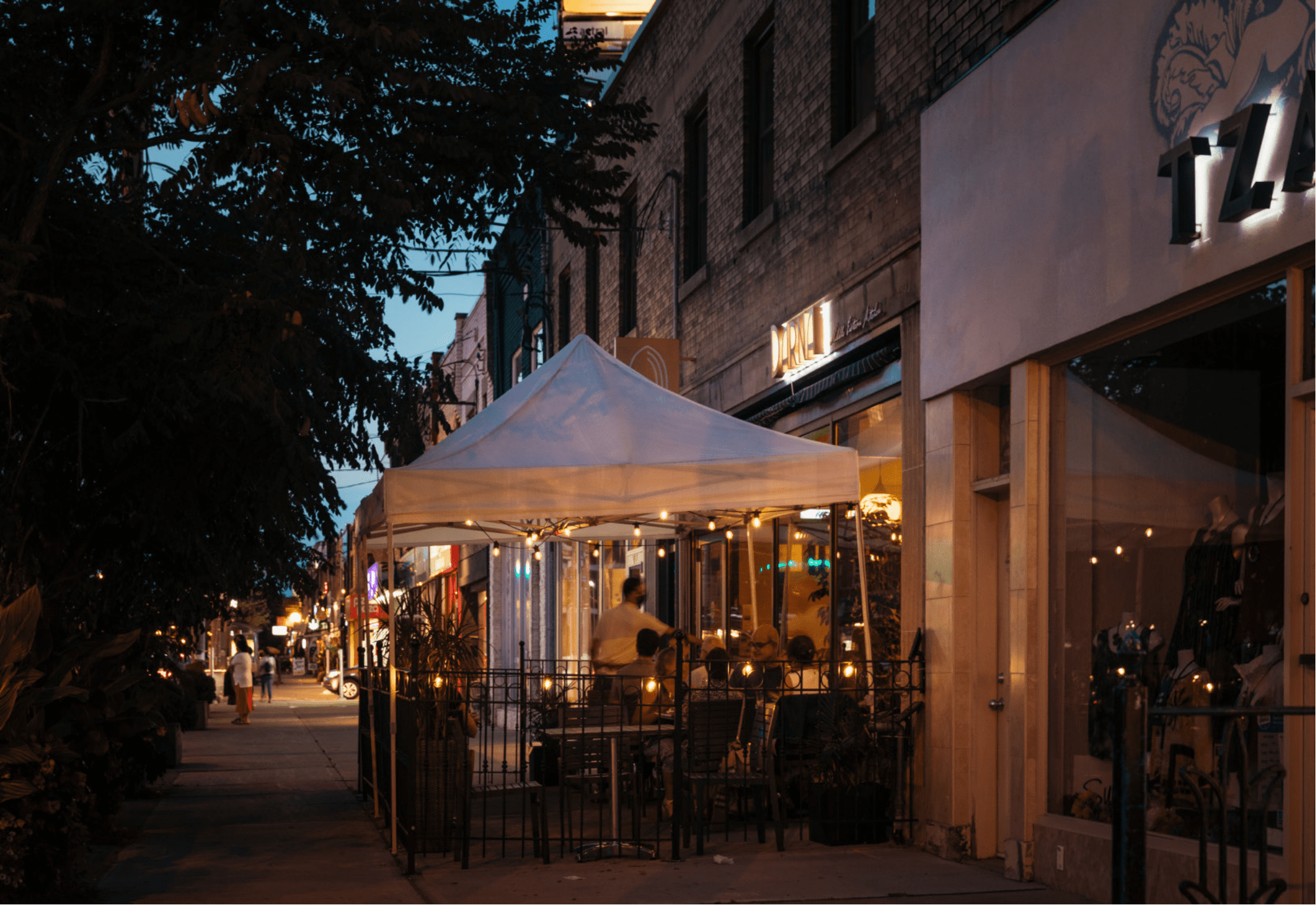 a tent with tables outside of a restaurant at night