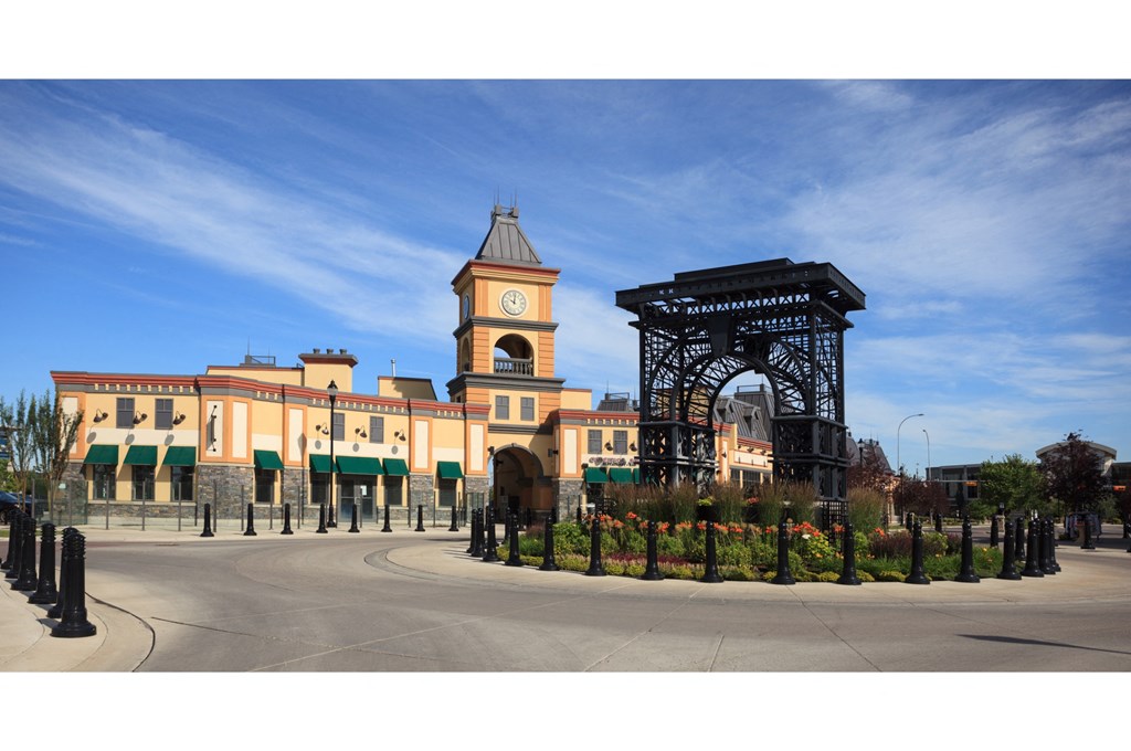 A large building with a clock tower and a large archway in front.
