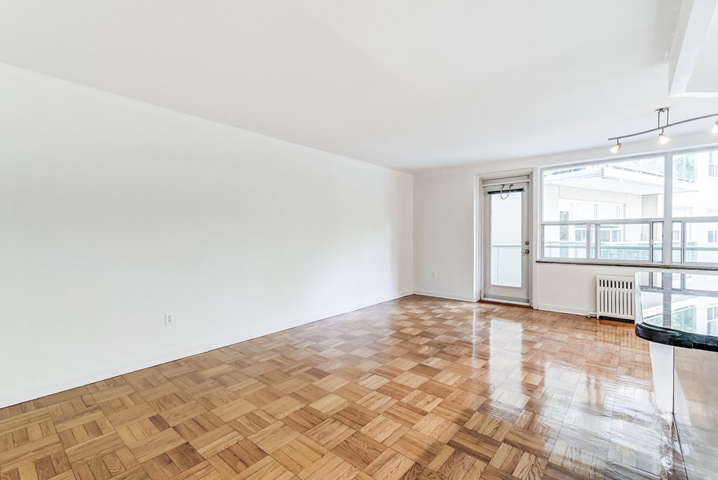 an empty living room with wood flooring and a balcony