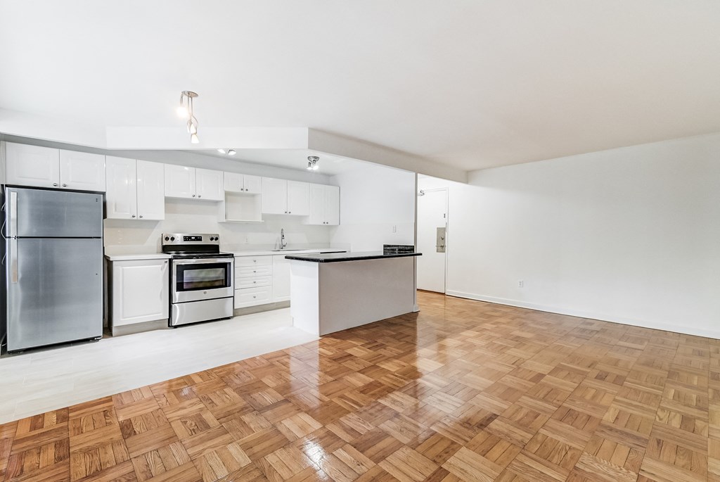a renovated kitchen with white cabinets and stainless steel appliances