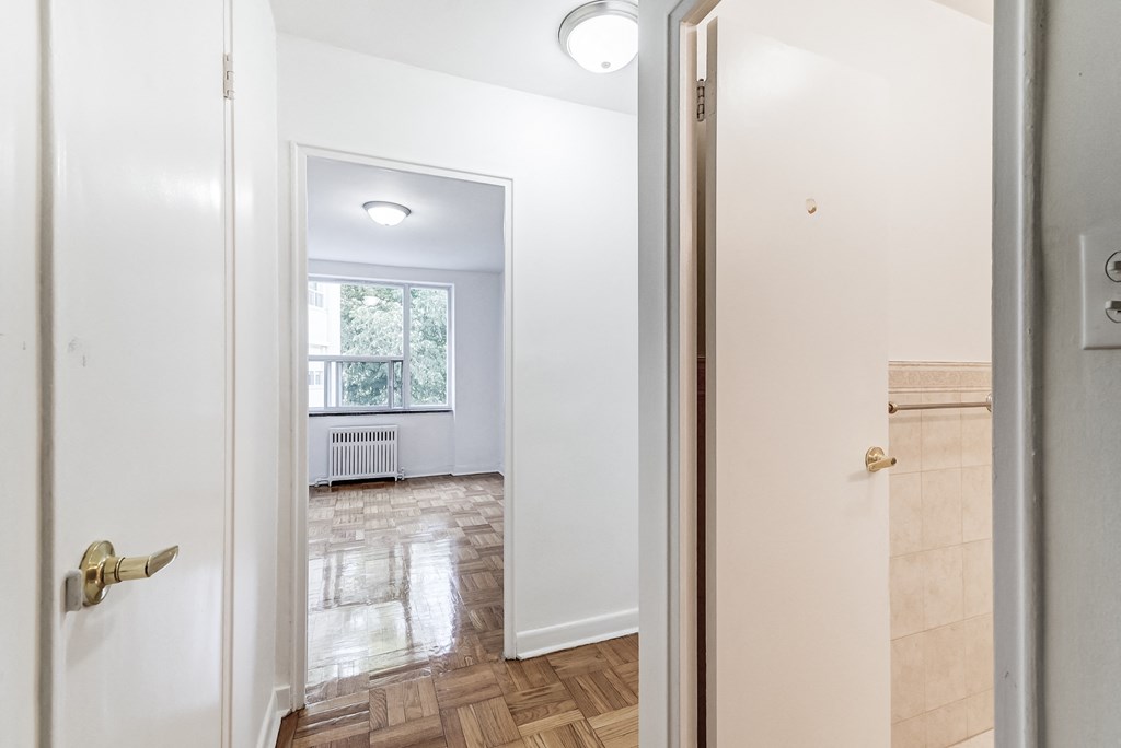 a living room with a window and a door to a bedroom