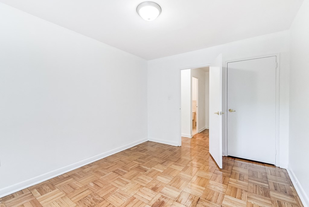 an empty room with wood flooring and a door to a closet