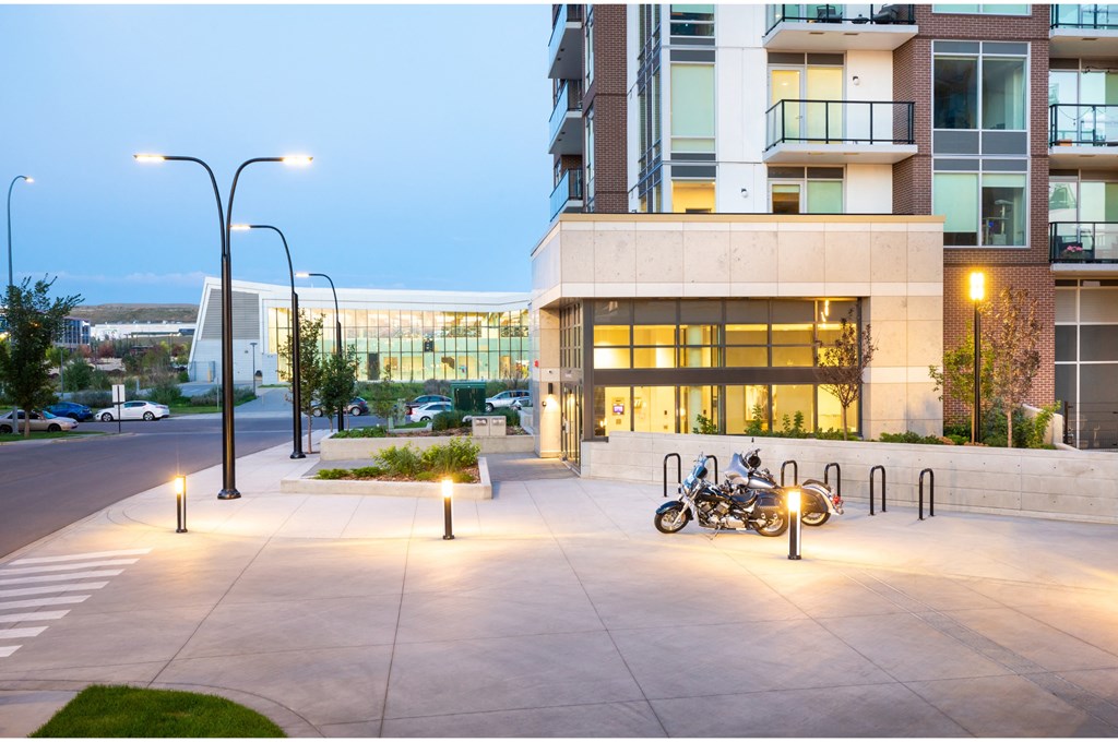 A modern building with a parking area in front.