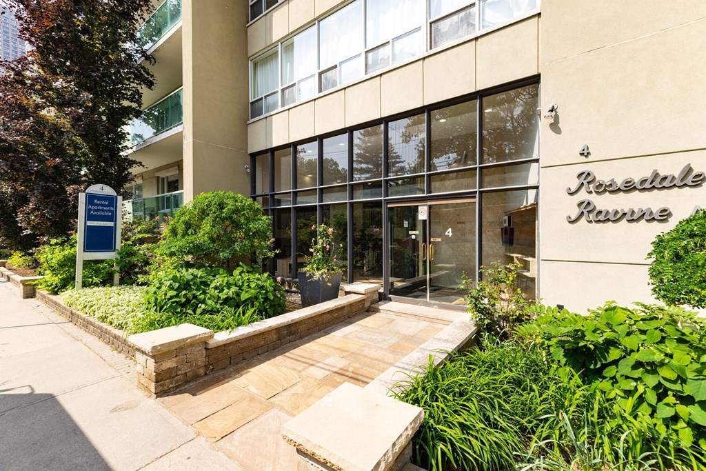an office building with a walkway and plants in front of it