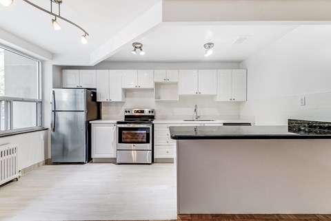a white kitchen with white cabinets and stainless steel appliances