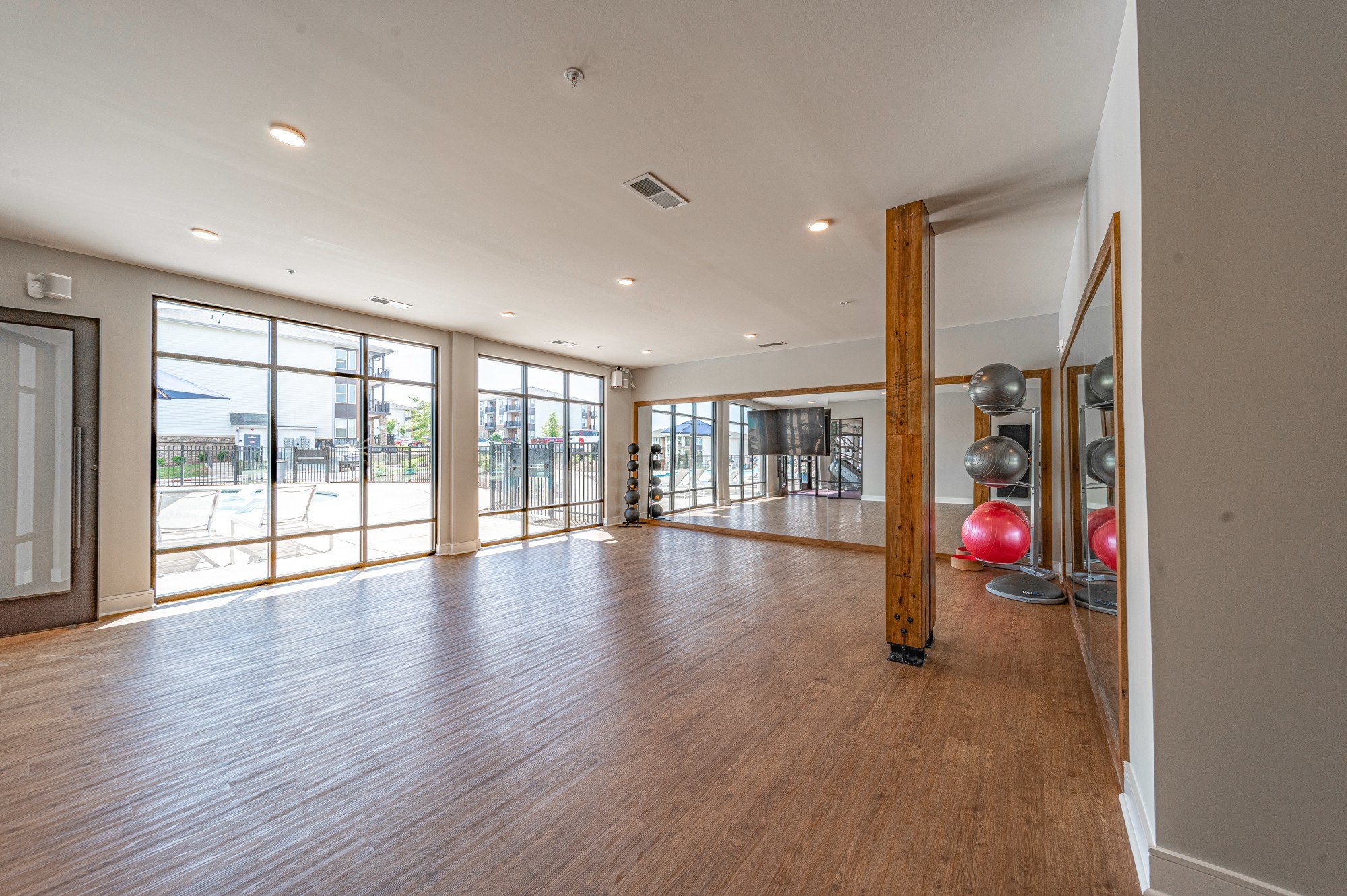a large living room with wood floors and glass doors