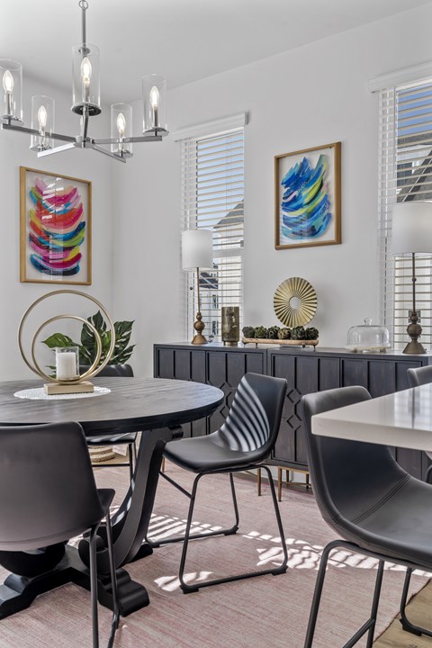 A modern dining room with a round table and chairs.