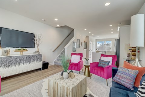 A living room with a white sofa and a pink armchair.