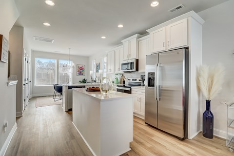 A kitchen with a white island and stainless steel appliances.