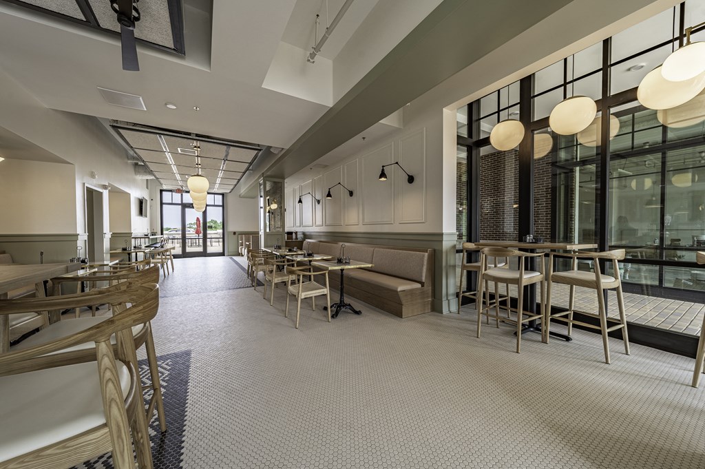 a rendering of a restaurant with a long communal table in the middle of the room