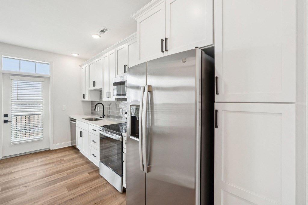 A modern kitchen with stainless steel appliances and white cabinetry.
