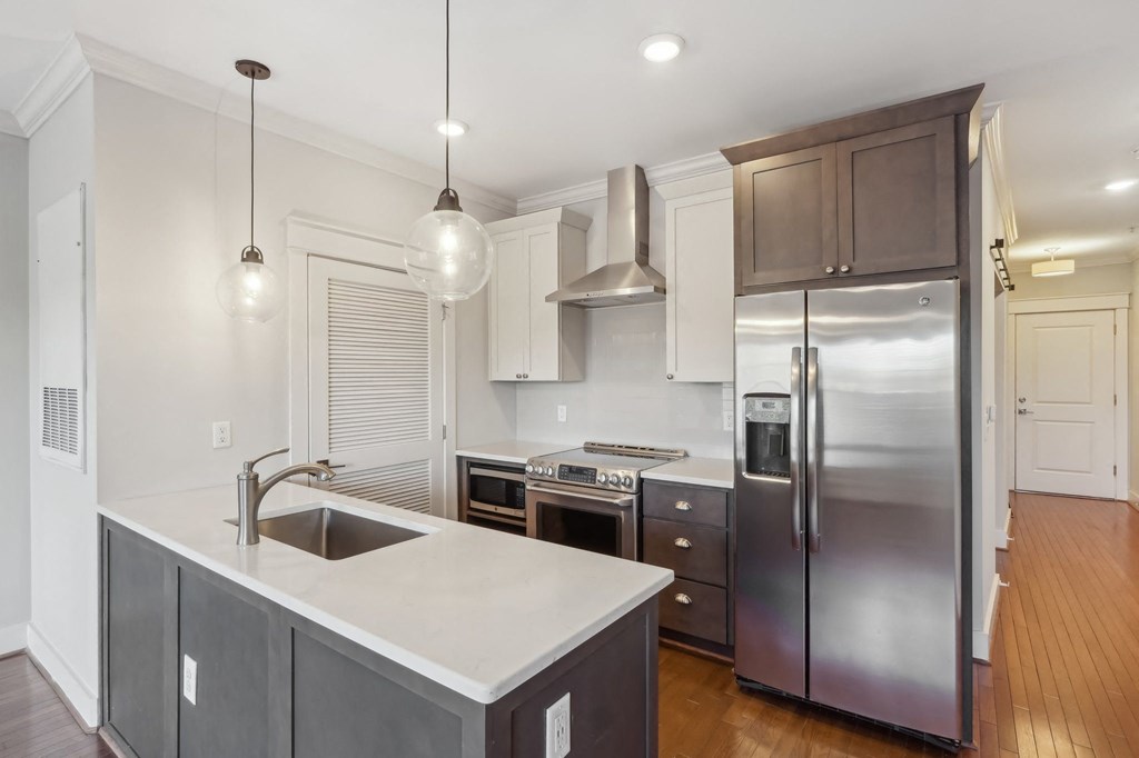 A modern kitchen with a stainless steel refrigerator and a sink with a faucet.