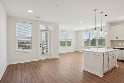 A kitchen with white cabinets and a wooden floor.