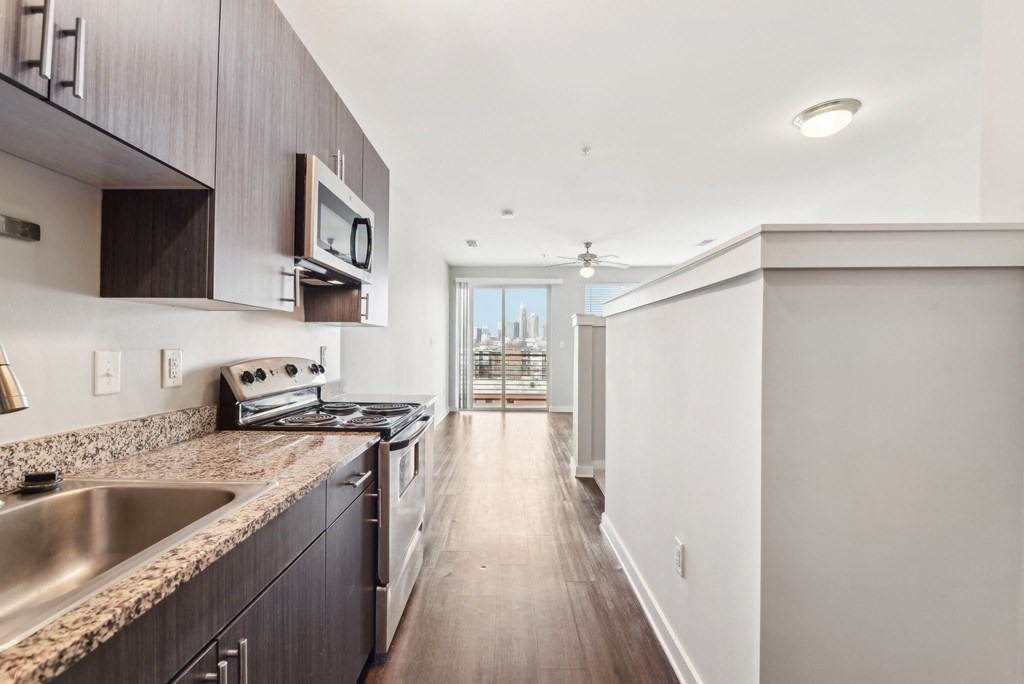 A modern kitchen with dark wood cabinets and a stainless steel sink.