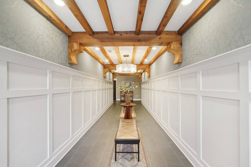 A long hallway with a bench and a light at the end.