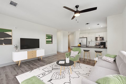 A living room with a white couch, a coffee table, and a television.