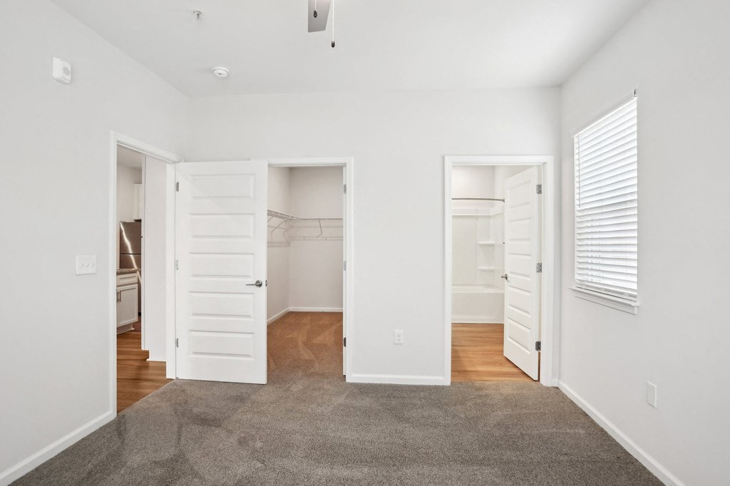 A room with white walls and a grey carpet.