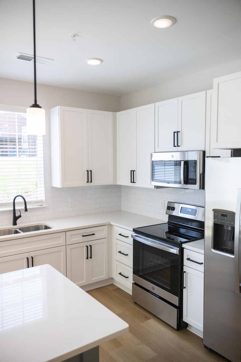 a kitchen with white cabinets and stainless steel appliances a kitchen with white cabinets and stainless steel appliances at Landon Green Artisan Cottages Apartments, North Carolina