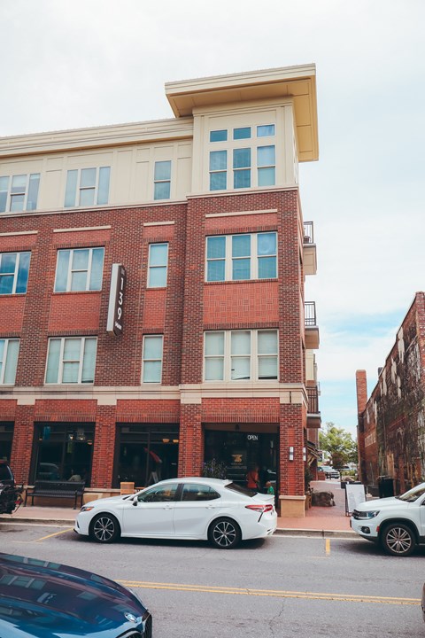 a white car parked in front of a brick building
