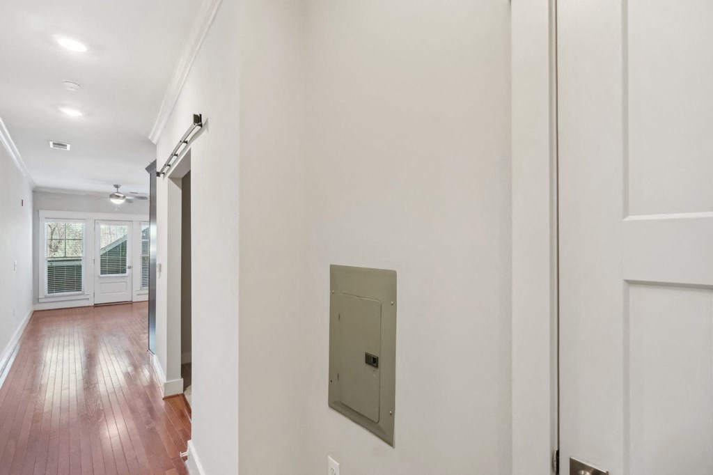 A long hallway with a white door on the right.