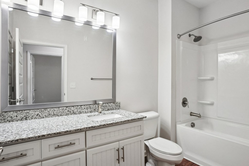 A white bathroom with a sink, toilet, and bathtub.