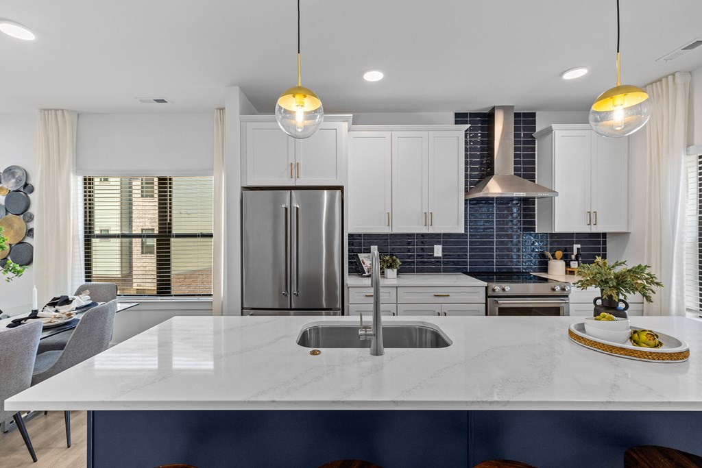 a kitchen with white cabinets a kitchen with white cabinets and a large island with a sink at The Collection Charlotte in Charlotte, NC, 28205