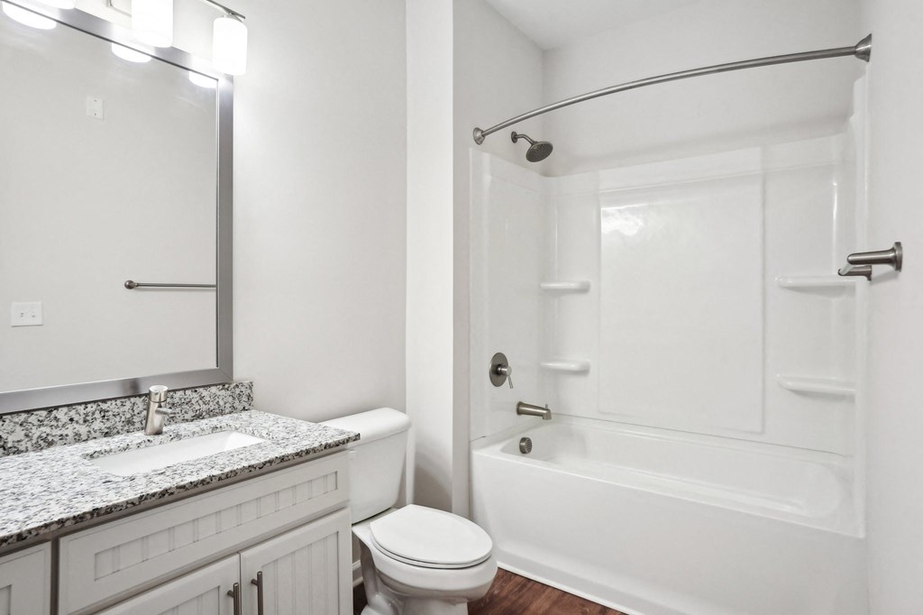 A white bathroom with a toilet, sink, and bathtub.