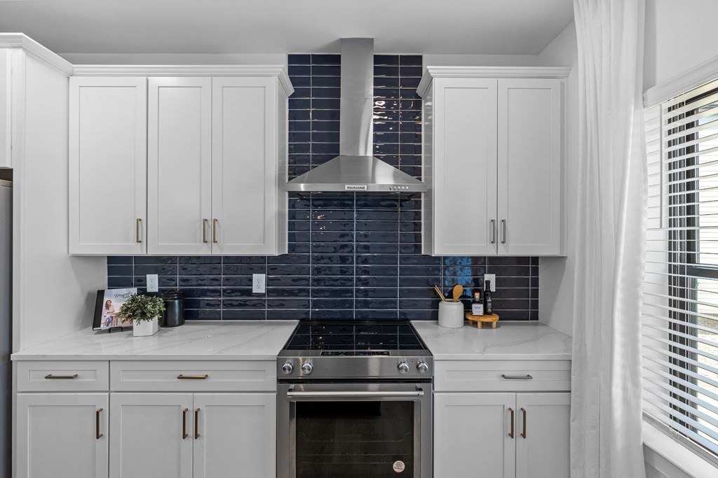 a kitchen with white cabinets and a stove and blue tiles at The Collection Charlotte in Charlotte, NC, 28205