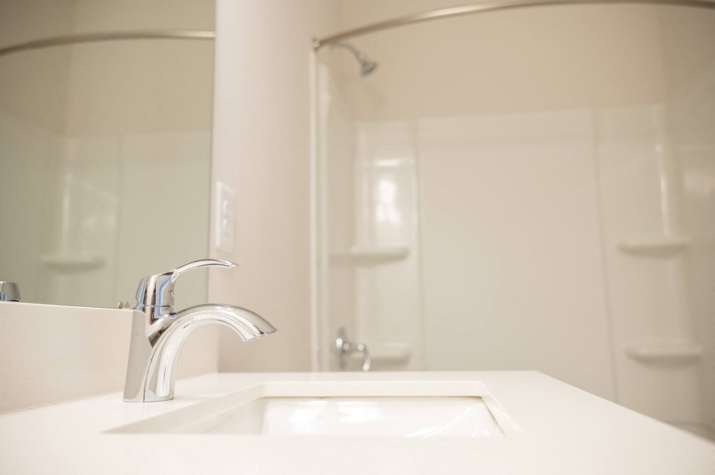 a bathroom with a sink and a mirror at Landon Green Artisan Cottages Apartments, Hickory, North Carolina