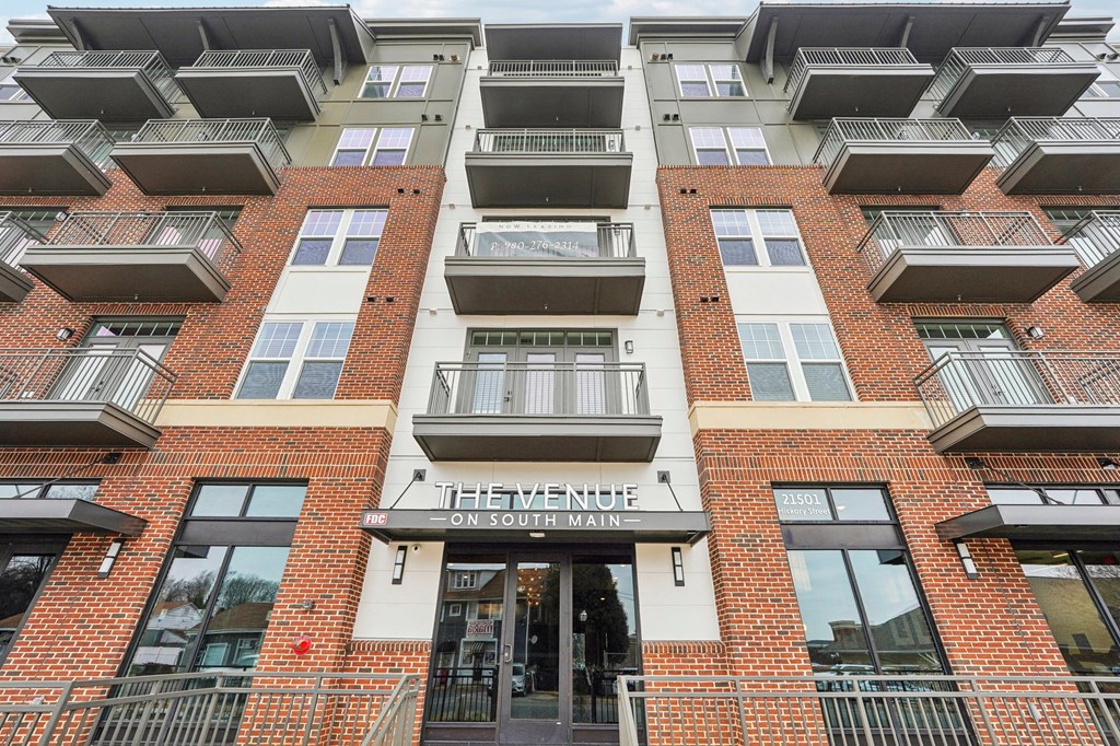 The Venue on South Main is a multi-story building with a red brick facade and balconies on each floor.