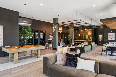 A modern living room with a pool table and comfortable seating.