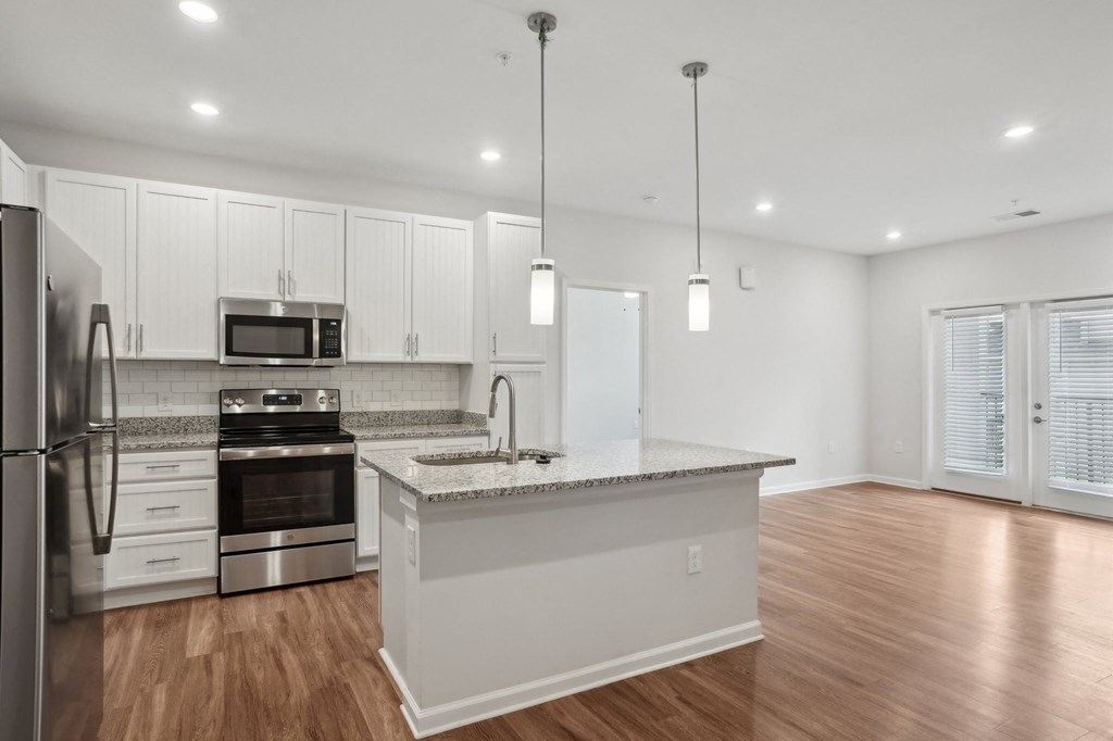 A modern kitchen with stainless steel appliances and white cabinets.