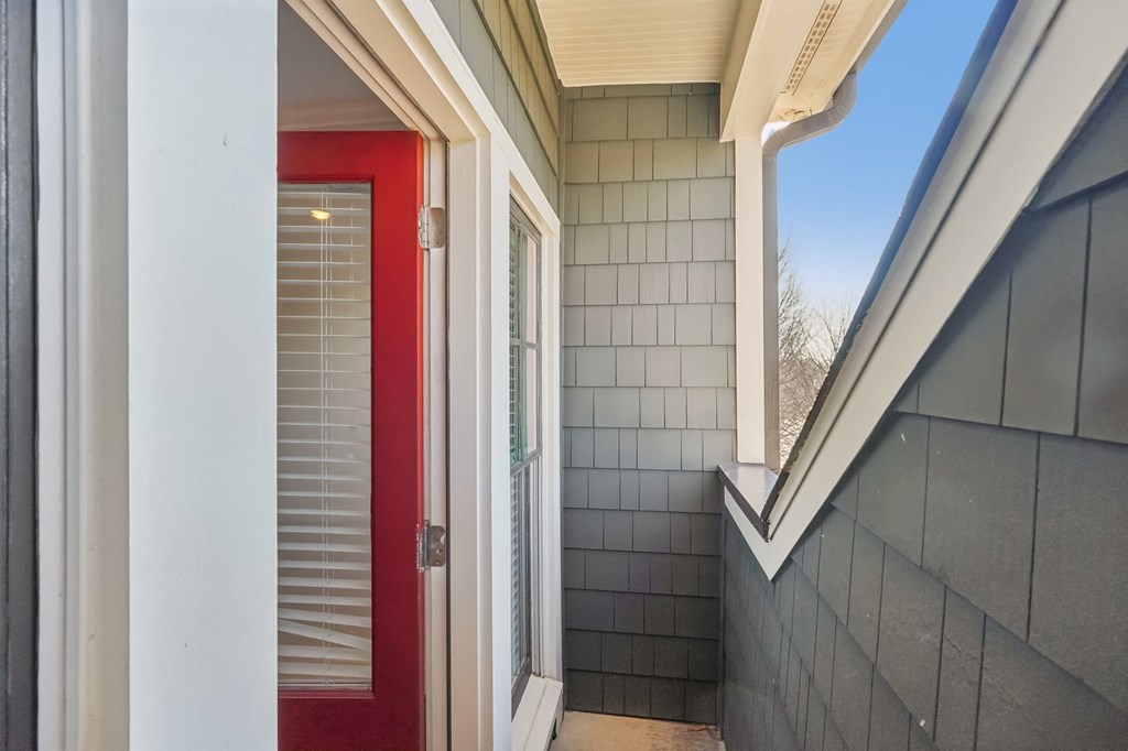 A red door is on the left side of a white wall.