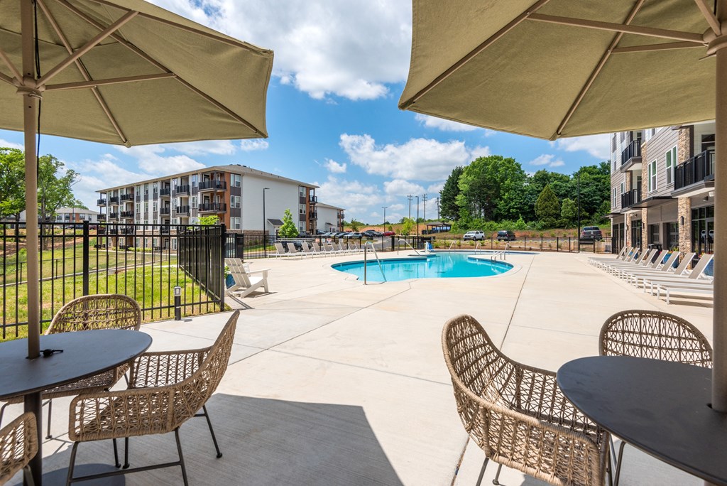 our apartments have a pool and patio with chairs and umbrellas