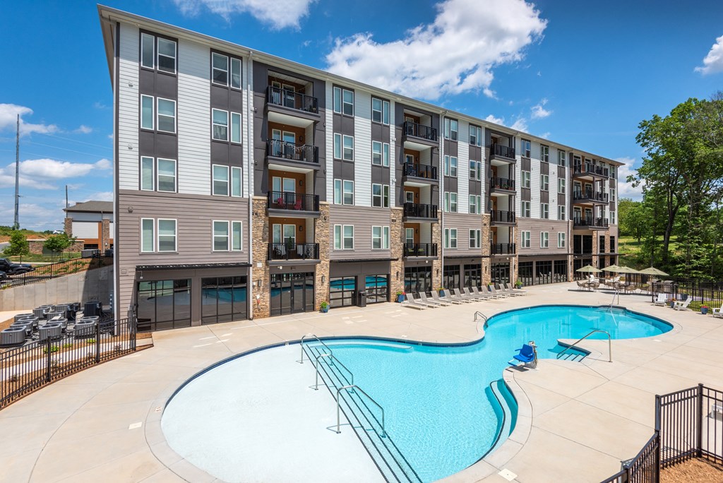 a swimming pool with an apartment building in the background