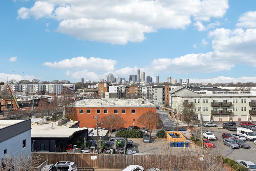 A city skyline is visible in the distance behind a parking lot.