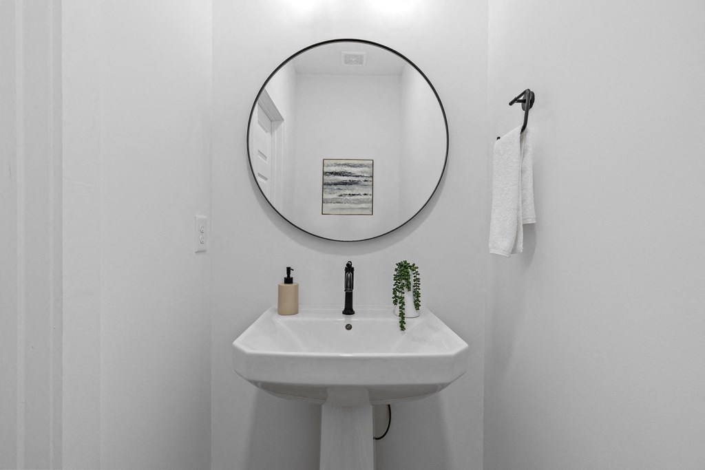 a white bathroom with a sink and a mirror at The Collection Charlotte in Charlotte, NC, 28205