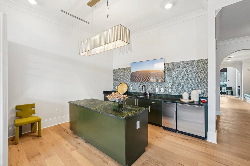 A kitchen with a green island and a yellow chair.