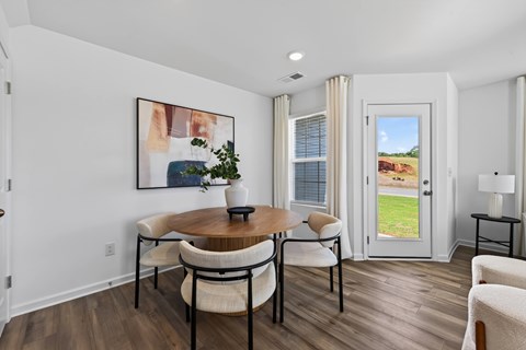 A dining room with a wooden table and chairs.