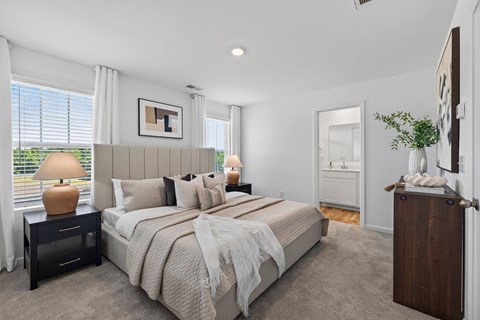 A bedroom with a large bed and a lamp on a side table.