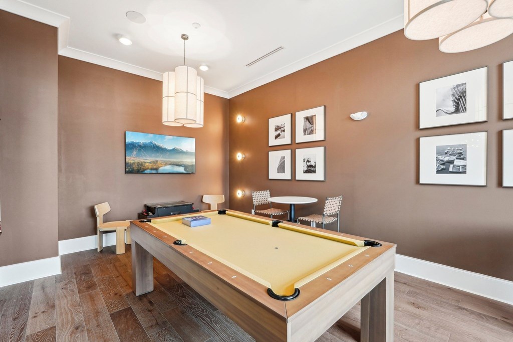 A pool table is in the middle of a room with brown walls.