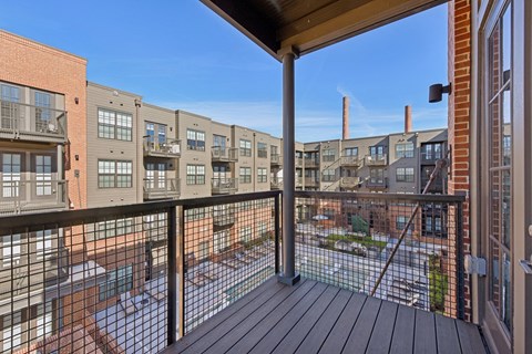 A balcony with a railing overlooks a parking lot.