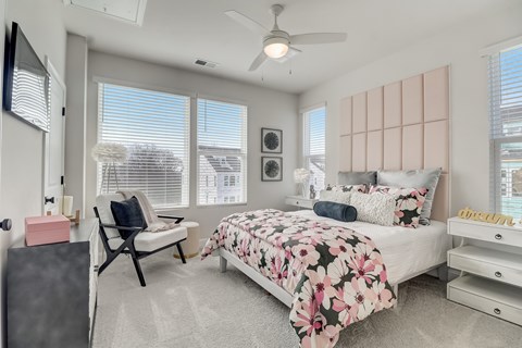 A bedroom with a large bed and a ceiling fan.