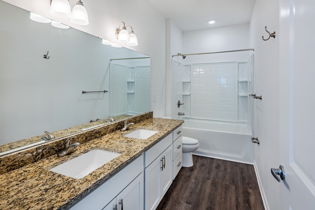 a bathroom with two sinks and a shower and a toilet